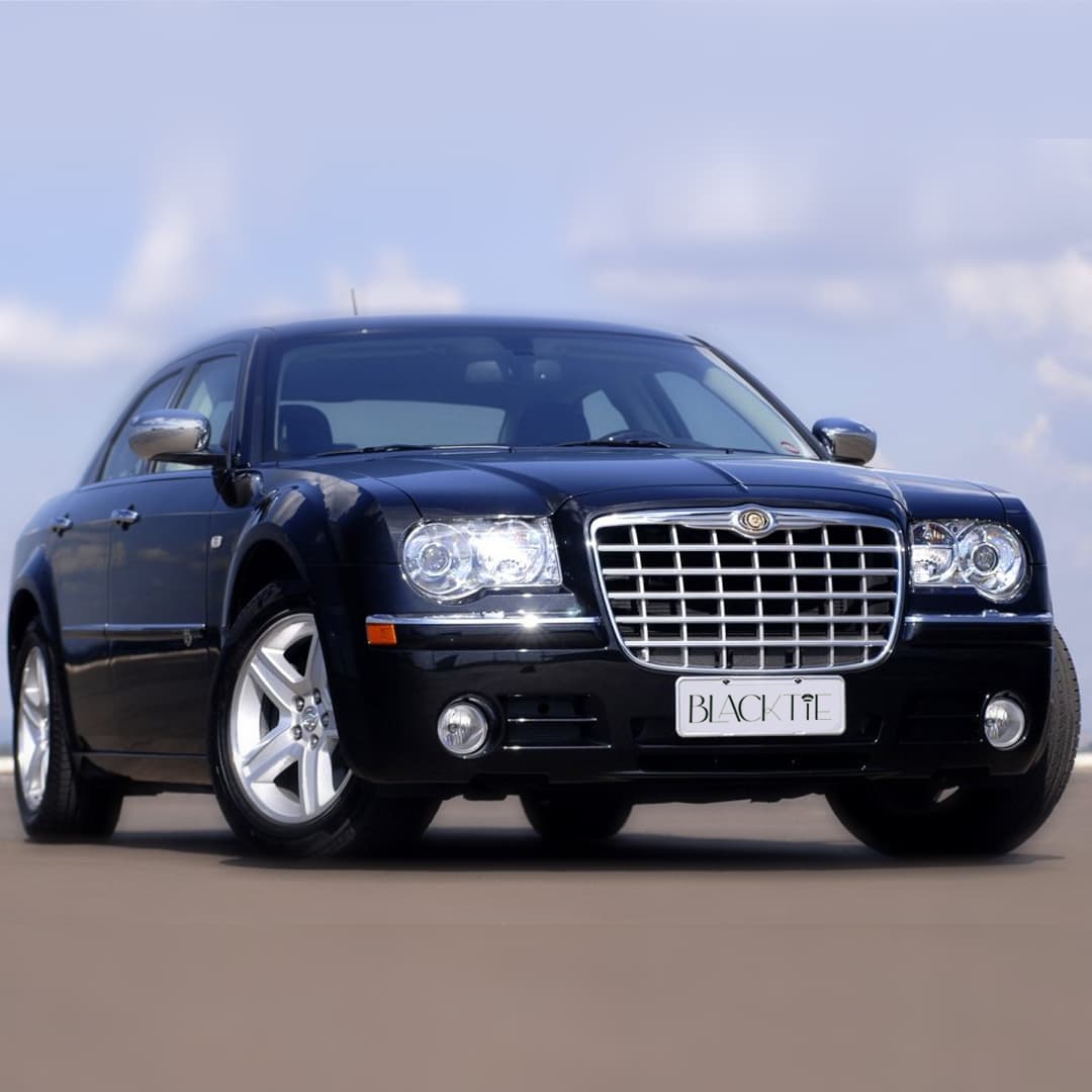 Sleek black Chrysler 300 luxury sedan with a chrome grille and silver alloy wheels.